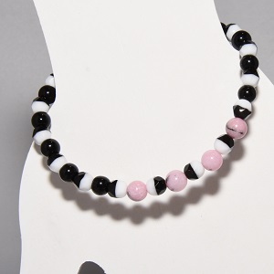 Humboldt Penguin conservation stretchy bracelet in black, white, and pink beads.